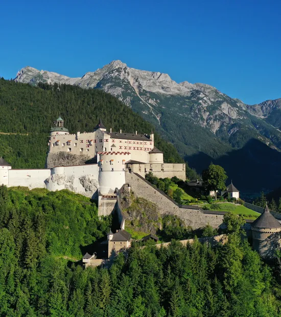 Mittelalterliche Burg Hohenwerfen umgeben von Alpenwald mit Bergkulisse im Hintergrund