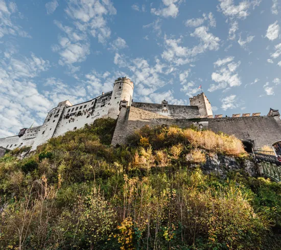 Historische Festung Hohensalzburg auf Hügel mit Standseilbahn und blauem Himmel