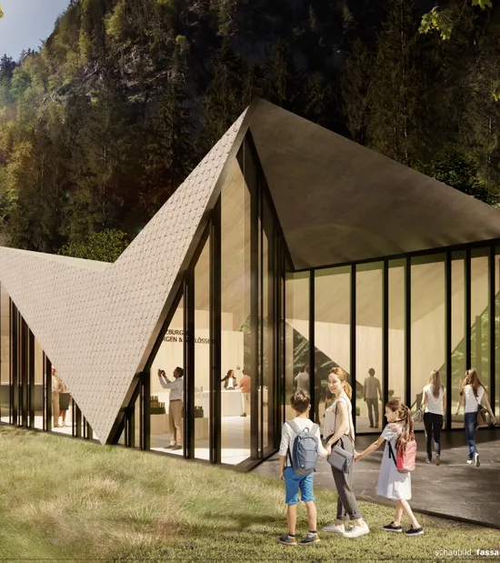 Modernes Besucherzentrum mit spitzem Dach in bewaldeter Berglandschaft